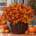 Artificial autumn flowers arranged in a woven planter; planter and decorations not included